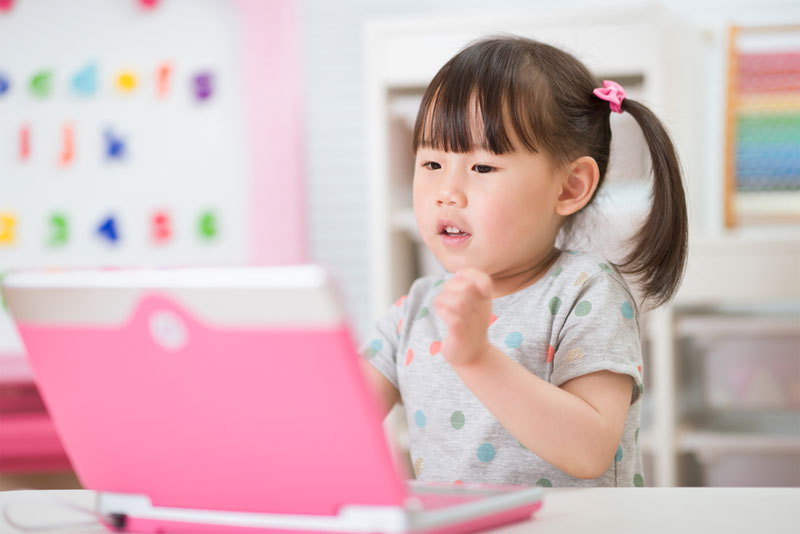 young girl using laptop for online learning during lockdown time